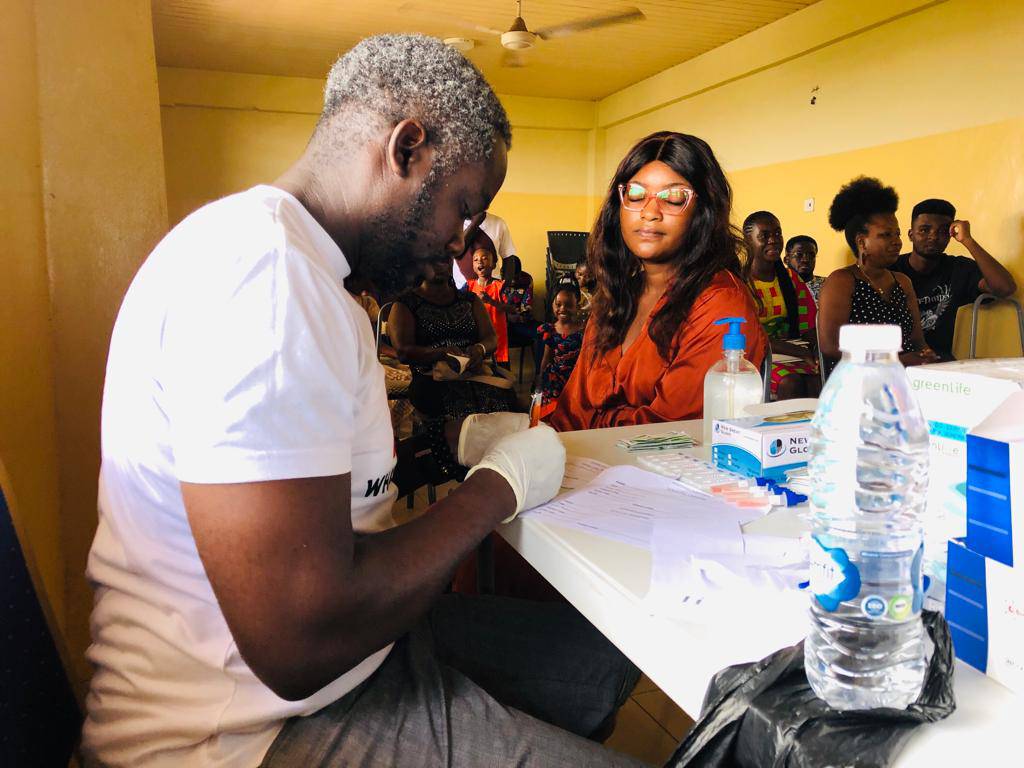 A PAHAM health worker recording screening results during a community outreach